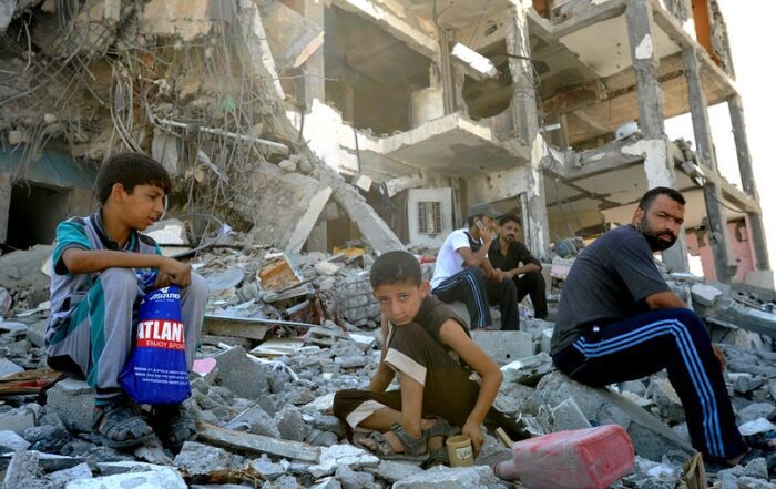Palestiniens dans les décombres de leur immeuble à Gazea en 2014 © Shareef Sarhan UN Photo