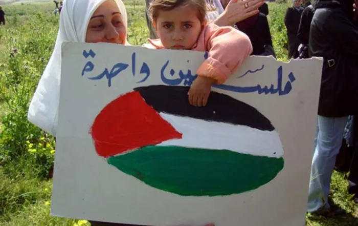 Enfant palestinien portant une pancarte pour la journée de la terre © ISM Palestine